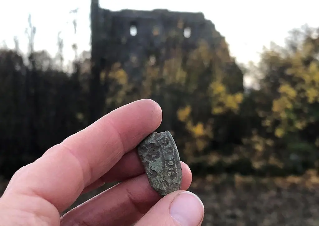 Hand som håller upp ett litet stenföremål med inskriptioner.