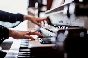 Närbild på händer som spelar på en orgel.