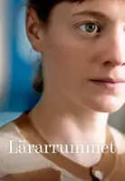 Filmaffisch från Lärarrummet som visar en närbild på en kvinnas ansikte. Hon har bruna ögon och brunt hår med lugg. 