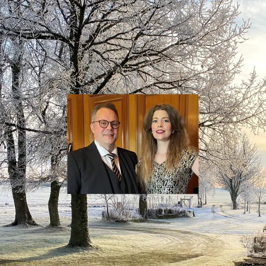 Johan Silfvenhjelm och Hanna Carlsson står bredvid varandra med ett vinterlandskap som bakgrund med snö på träden och en svagt lysande sol. 